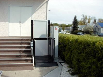 A vertical wheelchair lift installed outside a business